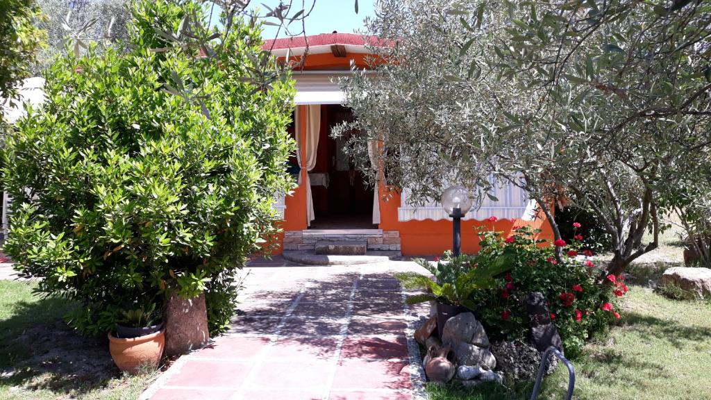 een oranje huis met bomen en bloemen ervoor bij Casa Vacanza Gaia Relax Pula in Pula