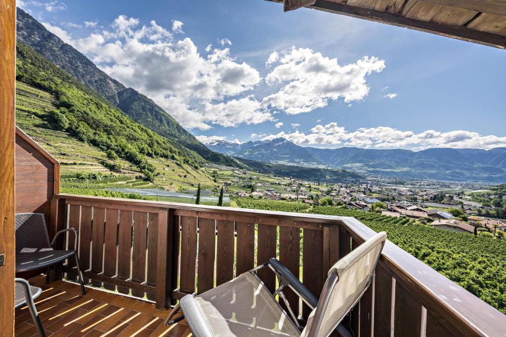 d'un balcon avec des chaises et une vue sur les montagnes. dans l'établissement Baumgartnerhof Appartment Holunder, à Lagundo