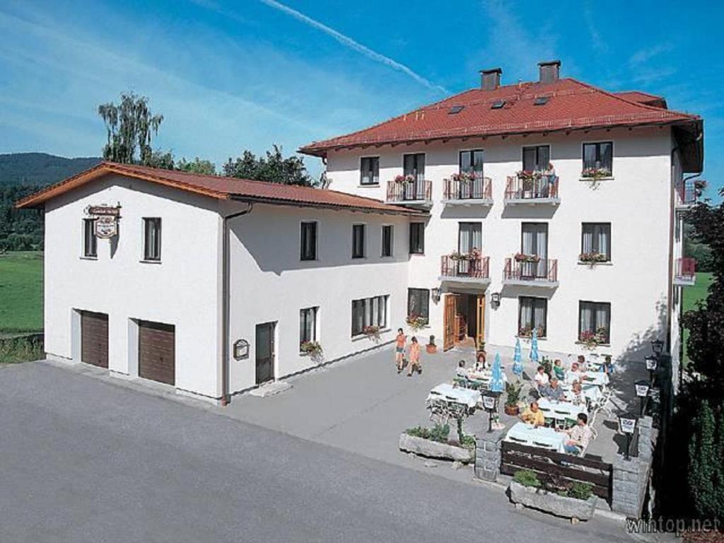 un gran edificio blanco con gente delante de él en Hotel Landgasthof Hacker, en Zachenberg