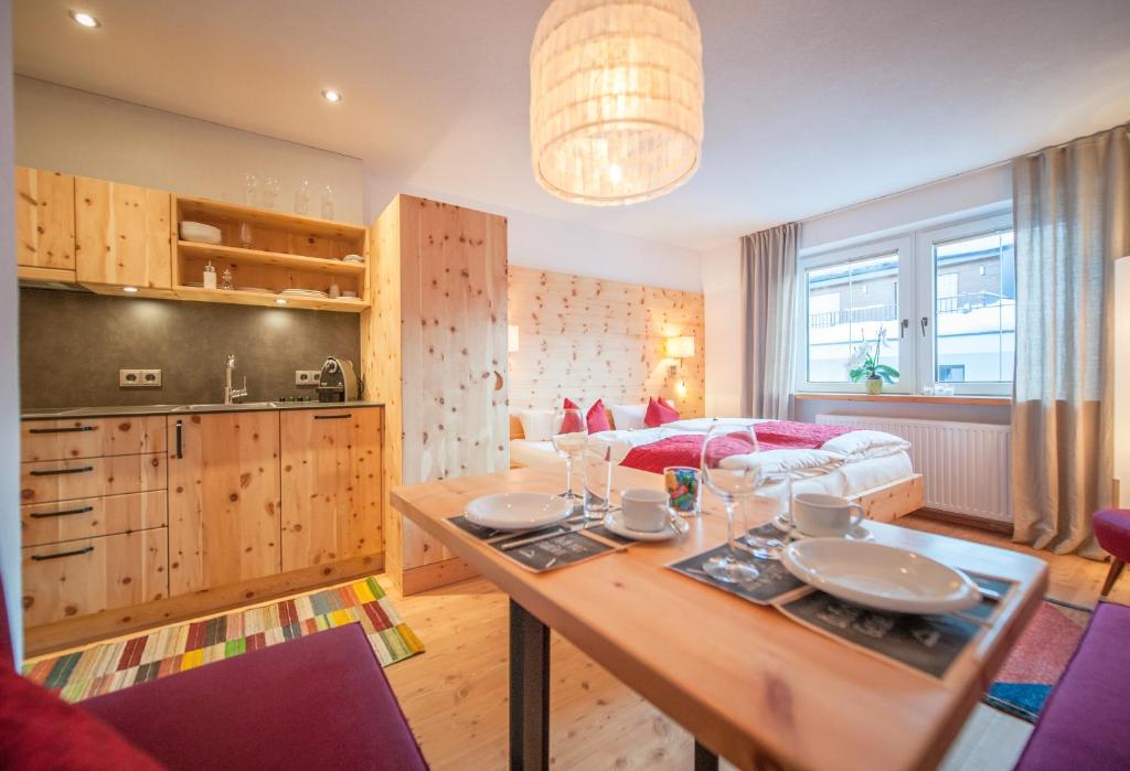 eine Küche und ein Wohnzimmer mit einem Tisch und einem Sofa in der Unterkunft Arlsuites in Sankt Anton am Arlberg