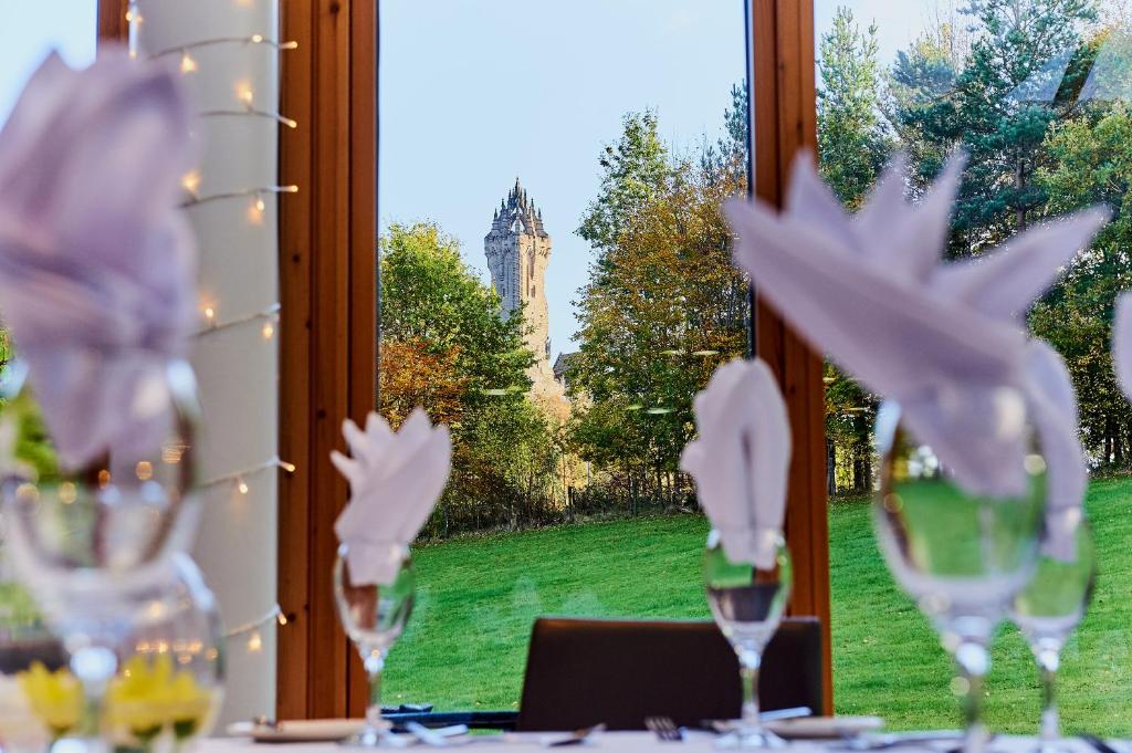 um grupo de copos de vinho sentados numa mesa em frente a uma janela em Stirling Court Hotel em Stirling