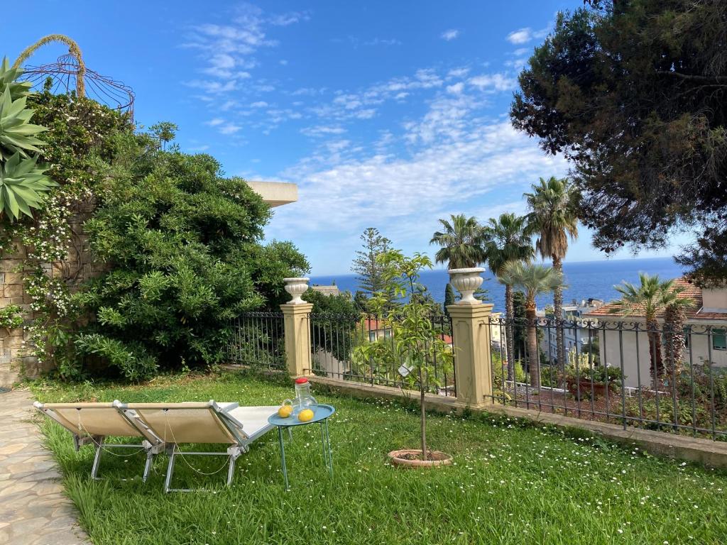 einen Hinterhof mit einem Tisch im Gras in der Unterkunft Villa Provenzale in Sanremo
