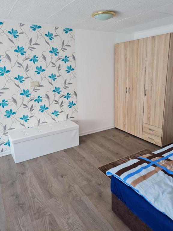 1 dormitorio con 1 cama y flores azules en la pared en Ferienhaus Mandy, en Müllrose