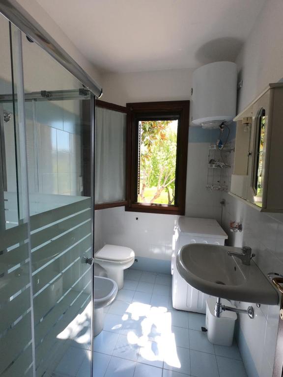 a bathroom with a toilet and a sink and a shower at Casa Tavolara in San Teodoro