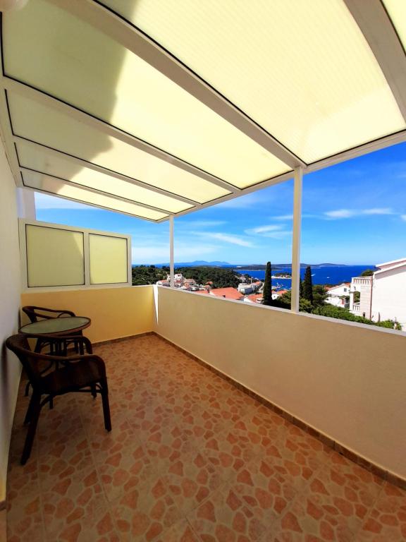 a balcony with a table and a view of the ocean at Apartments and Rooms Jasna in Hvar
