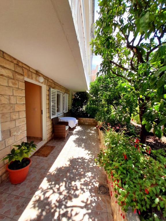 a patio with plants and trees and a building at Apartments and Rooms Jasna in Hvar