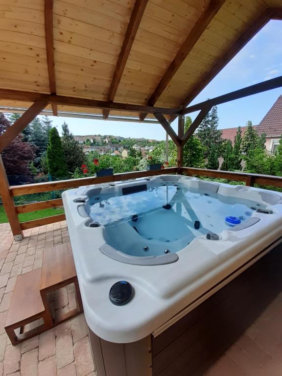 a jacuzzi tub on a patio with a roof at Flamingo Vendégház in Eger