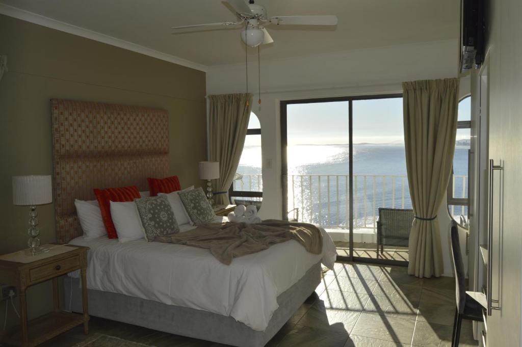a hotel room with a bed and a window at Harbourview Lodge in Gordonʼs Bay