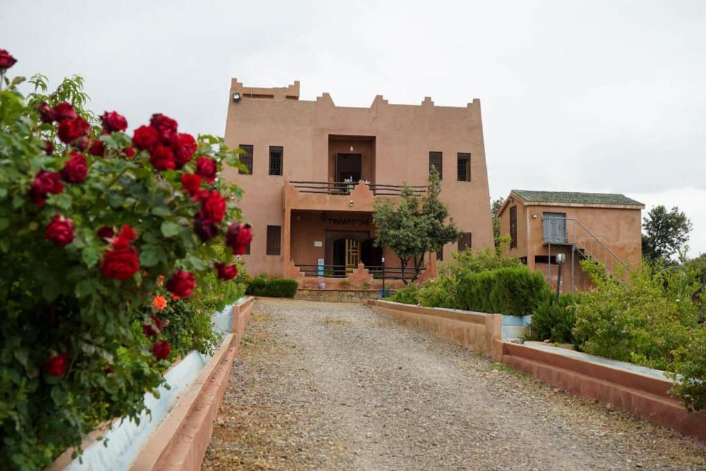 a house with red roses in front of it at Maison d'hôtes Tinwitchi in Azilal