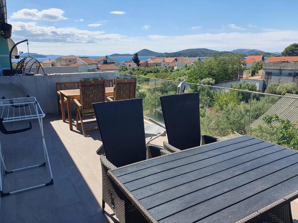 a balcony with a table and chairs and a view at Muring Apartments in Tribunj