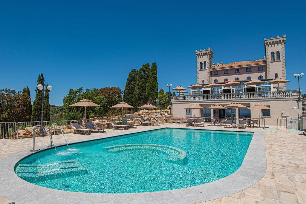 una gran piscina frente a un edificio en Castello Bonaria Wine & Spa Resort en Campiglia Marittima