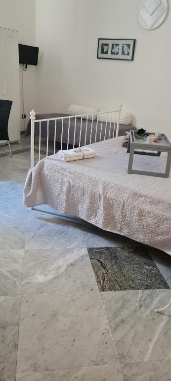 ein Schlafzimmer mit einem weißen Bett und einem Tisch in der Unterkunft le ginestre in centro in Salerno