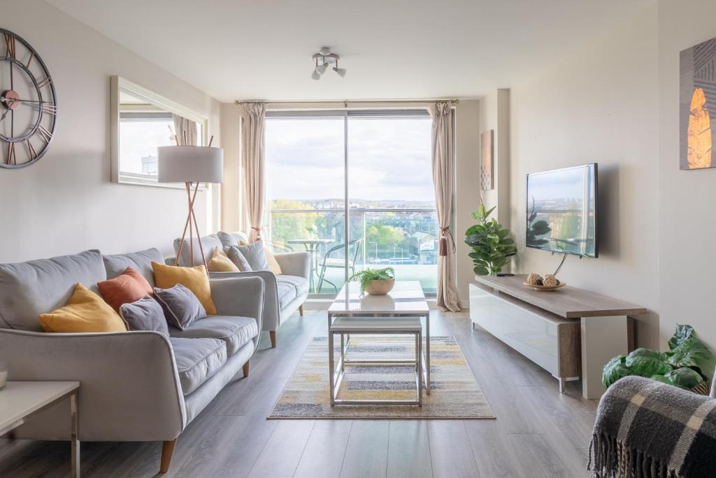 a living room with a couch and a table at Luxury Riverview City Centre Apartment in Glasgow