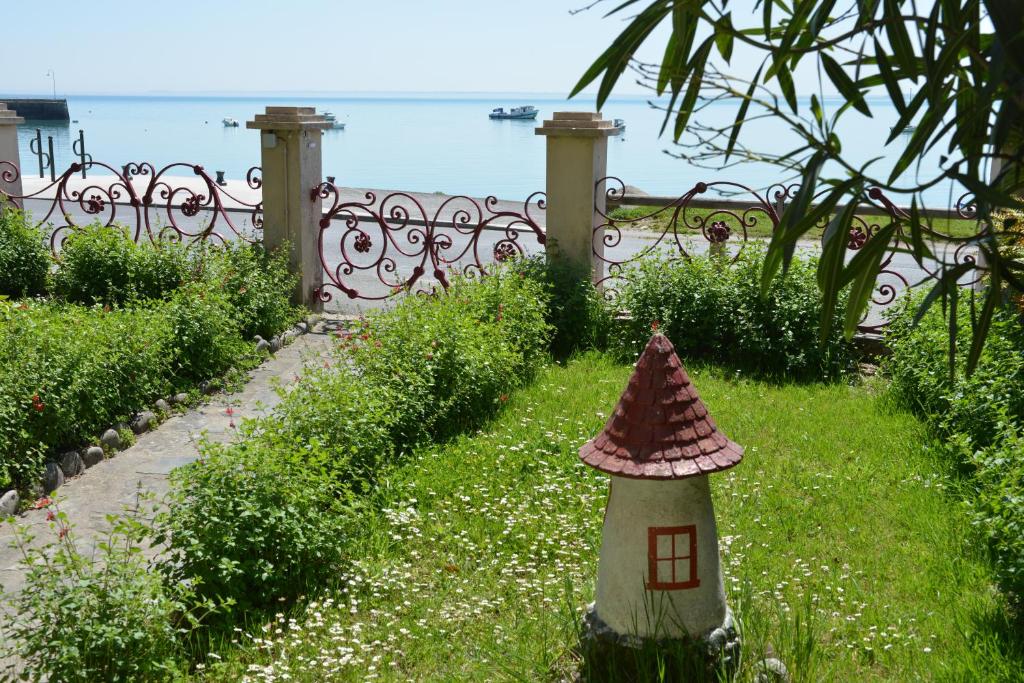 a small bird house in the grass near a fence at La Mouette in Cancale