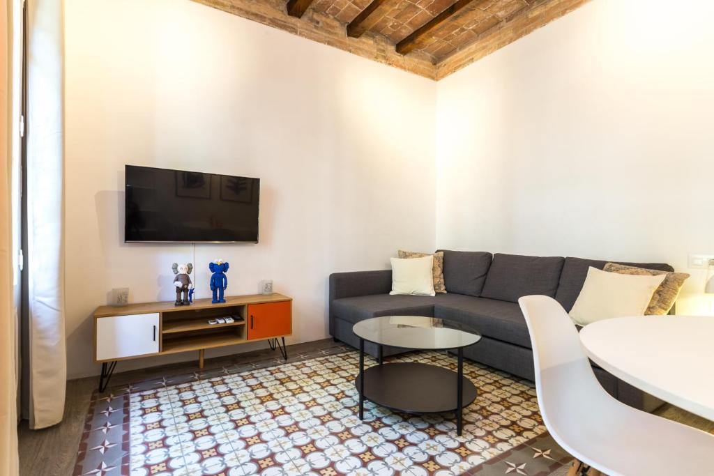 een woonkamer met een bank en een tv bij Stay Unique Apartments Corsega in Barcelona