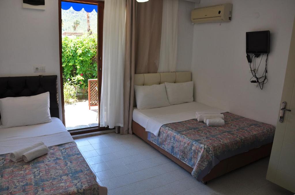 - une chambre avec 2 lits et une porte donnant sur une terrasse dans l'établissement Adrasan Shambala, à Adrasan