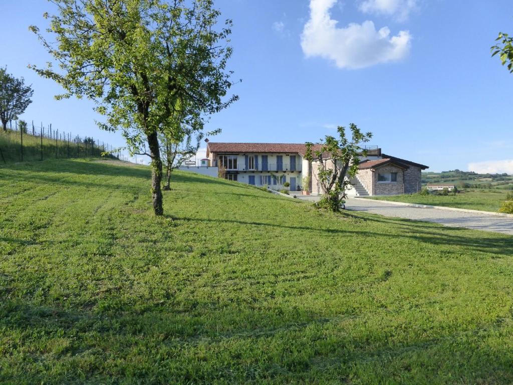 a house on a hill with a tree in the grass at Rosatea B&B in Chieri