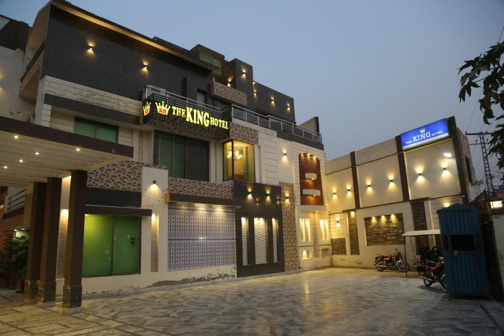 a building with a parking lot in front of it at The King Hotel in Multan