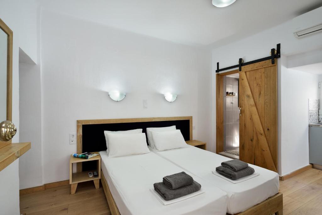 a bedroom with a large white bed with two towels on it at Urban Studios Manos in Chania Town