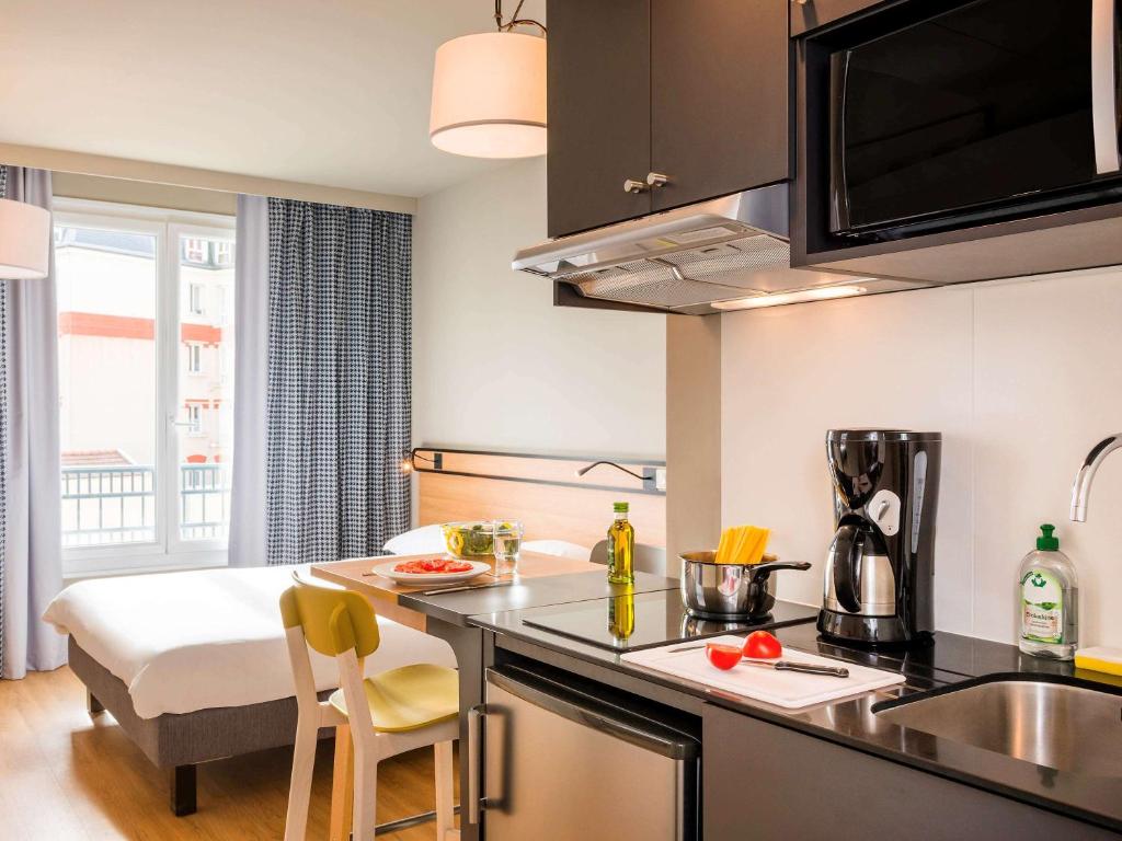 a kitchen with a sink and a counter top at Aparthotel Adagio Access La Défense Puteaux in Puteaux