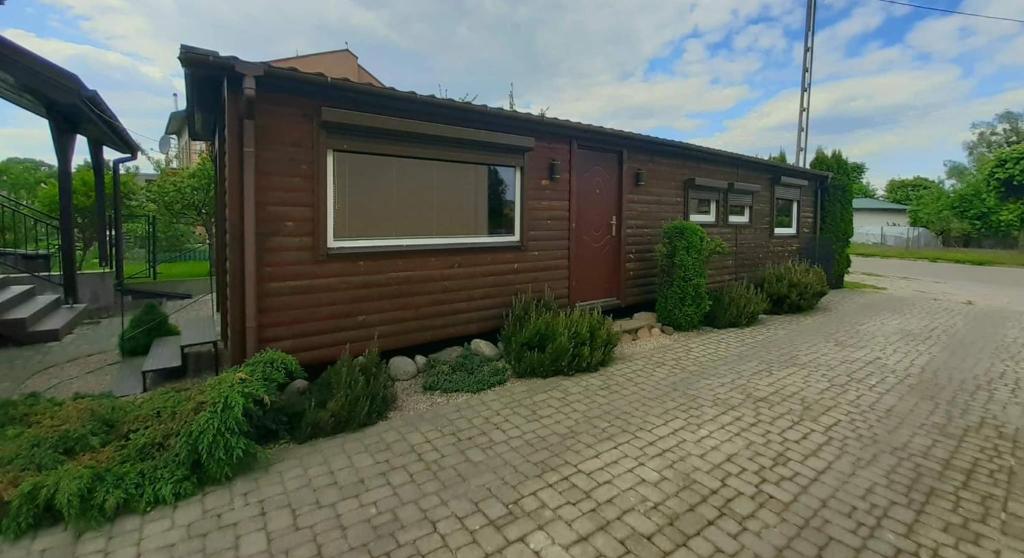 une petite cabine avec fenêtre sur une route en briques dans l'établissement Twój wypoczynek, à Augustów