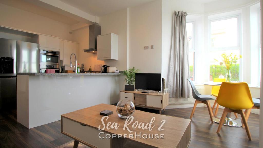 a kitchen and living room with a table and chairs at Beautiful apartments on the sea front - Sea Road 2 in Felixstowe