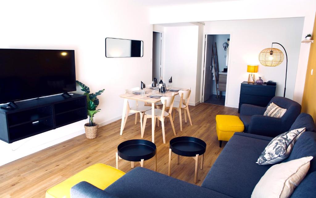 a living room with a couch and a table at Rives Occitanes, Appartement Toulouse Purpan in Toulouse