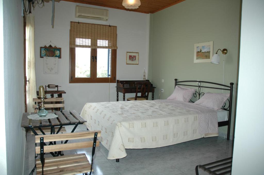 a bedroom with a white bed and a table at Elenis Olive green Studio in Petra