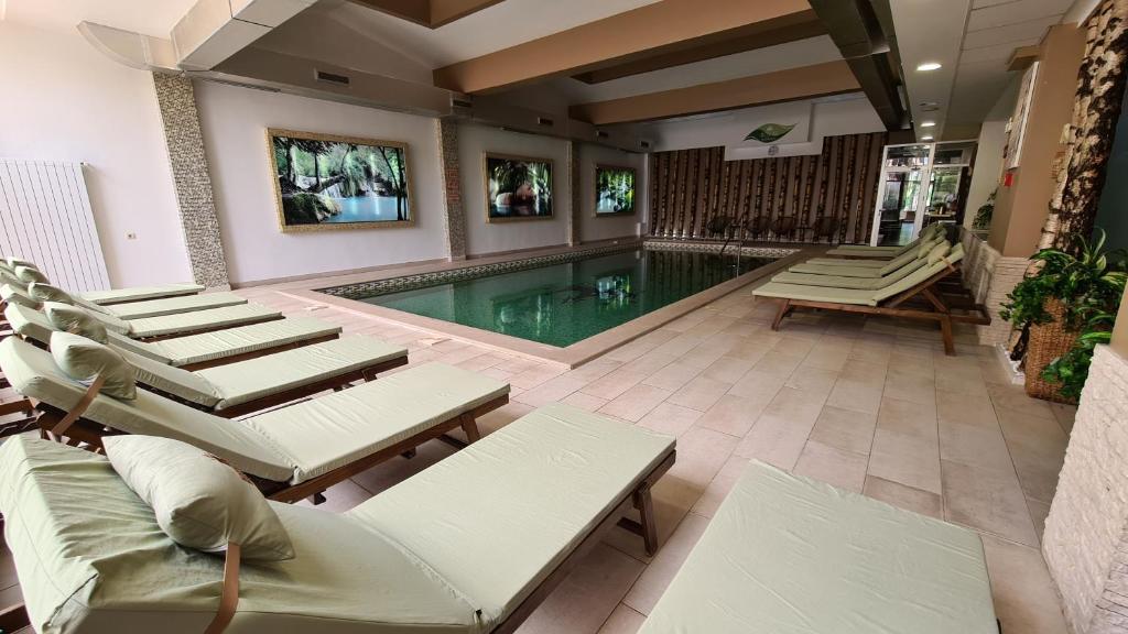 a pool with chaise lounge chairs and a swimming pool at Hotel Royal Spa in Banja Koviljača
