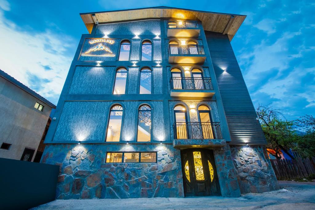 a blue building with lights on it at night at Hotel Mestia Inn in Mestia