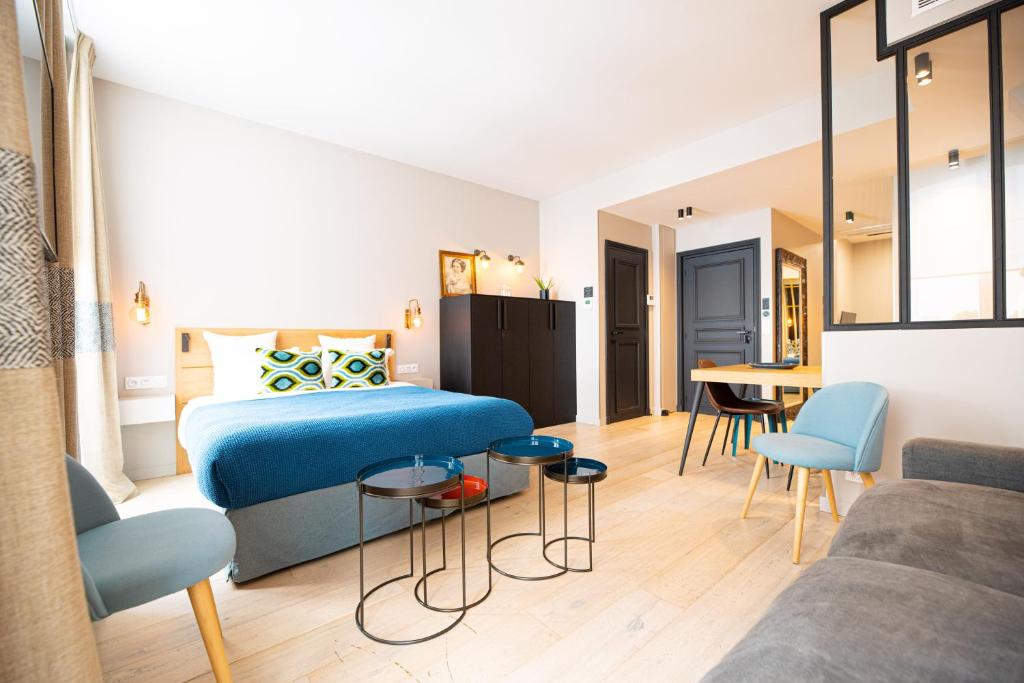 una camera da letto con un letto, un tavolo e un divano di Résidence du Louvre a Parigi