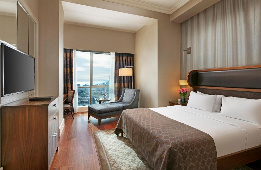 a hotel room with a bed and a flat screen tv at Titanic Business Kartal in Istanbul