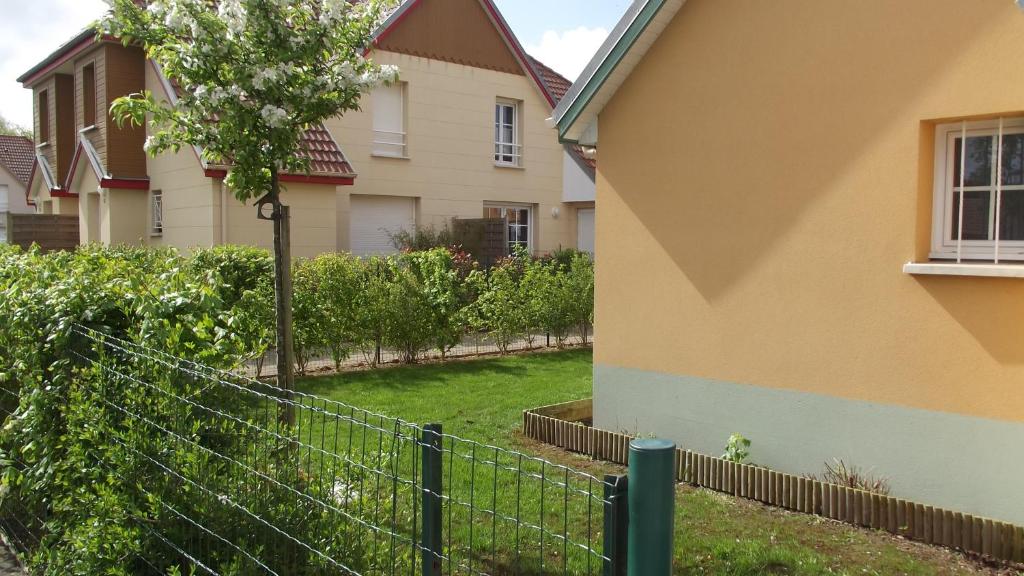 una cerca en un patio al lado de una casa en Les Pluviers en Baie, en Saint-Valery-sur-Somme