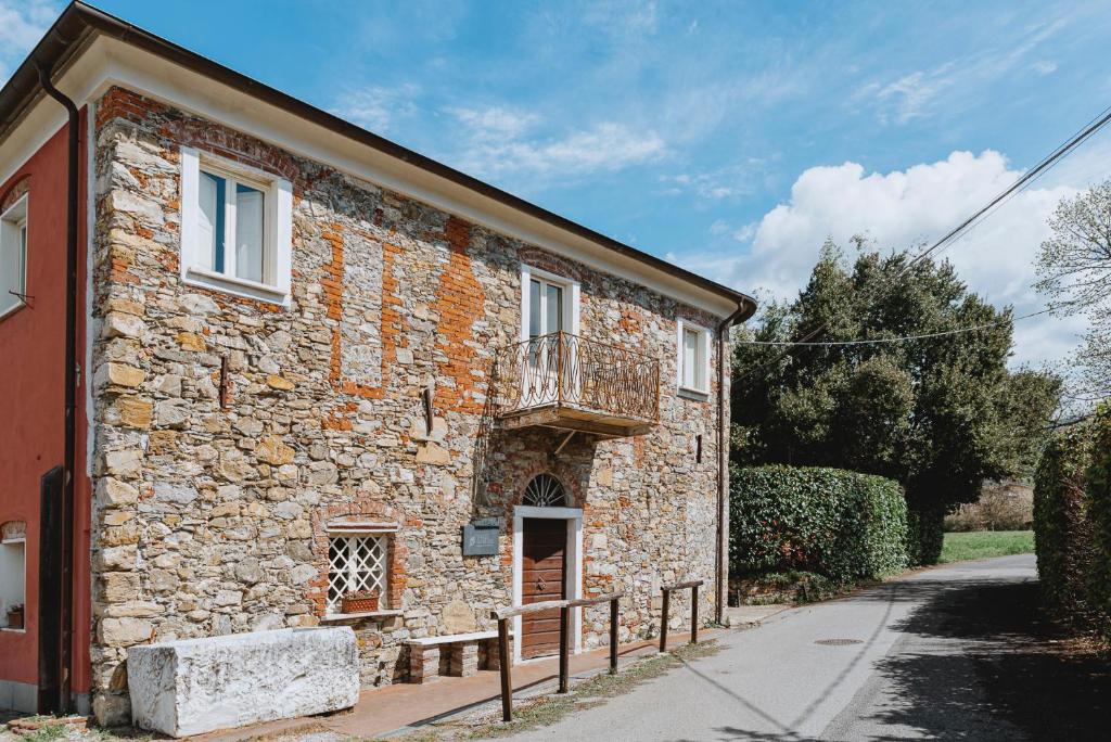 a stone building with a balcony on the side of it at Un Angelo Alla Mia Tavola in Sarzana
