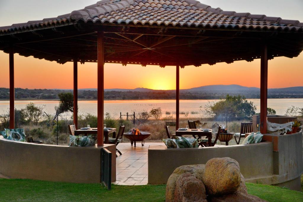 a patio with tables and a view of a lake at Kameeldrift Waterfront Estate & Resort in Brits