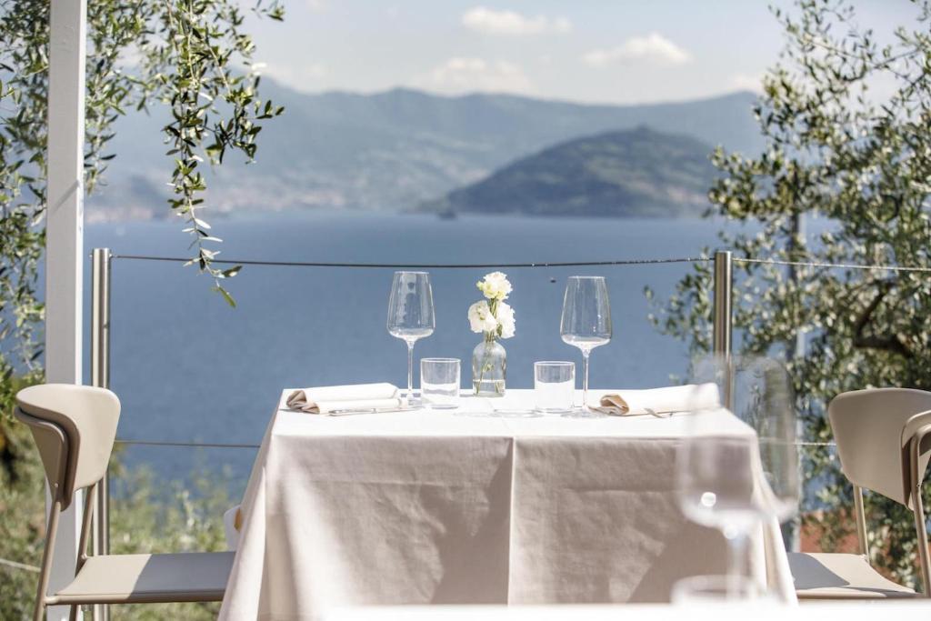 a table with a white table cloth and wine glasses at Hotel Miranda in Riva di Solto