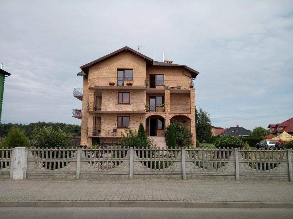 ein Gebäude mit einem Zaun davor in der Unterkunft Pokoje Gościnne Grzybowo in Grzybowo