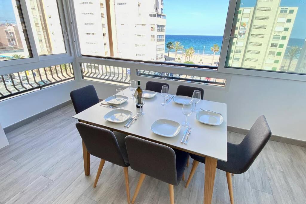a dining room with a table and chairs and the ocean at Central Modern Apartment 3 bed 2 bath in El Campello