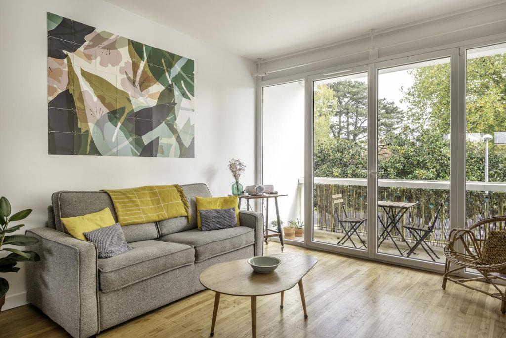 a living room with a couch and a table at MANGIN appartement moderne et chaleureux au coeur de Nantes in Nantes