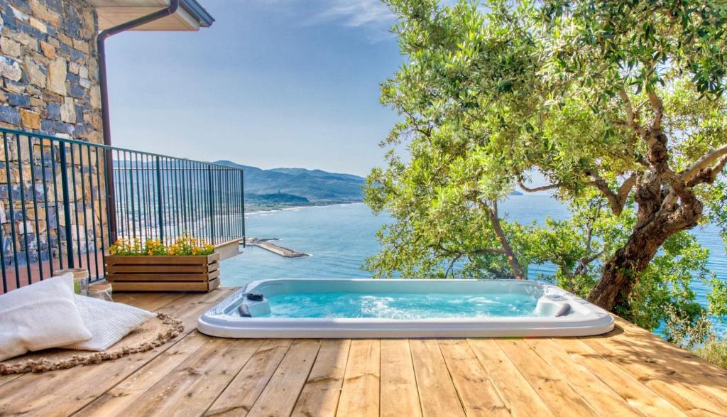 bañera de hidromasaje en una terraza con vistas al agua en Borgo Eleatico, en Casal Velino