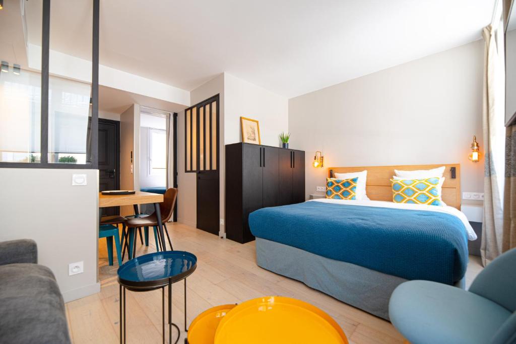 um quarto de hotel com uma cama e uma mesa em Résidence du Louvre em Paris