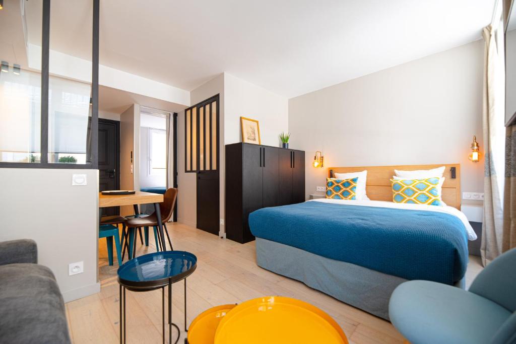 a hotel room with a bed and a table at Résidence du Louvre in Paris