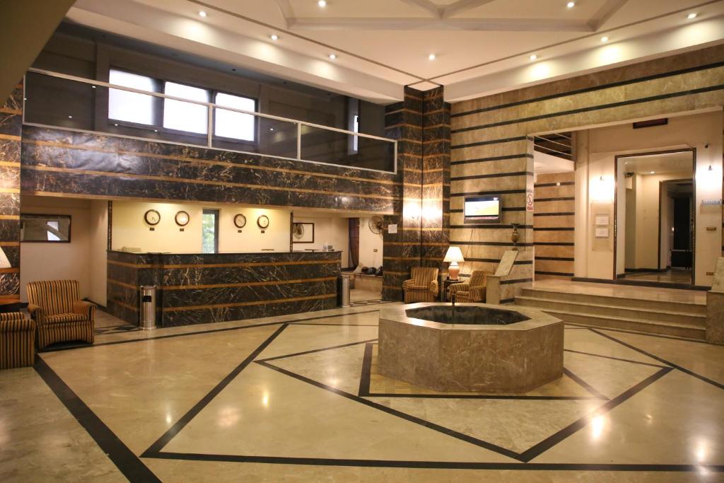 a lobby with a fountain in the middle of a building at Carlton Tower Hotel Lahore in Lahore