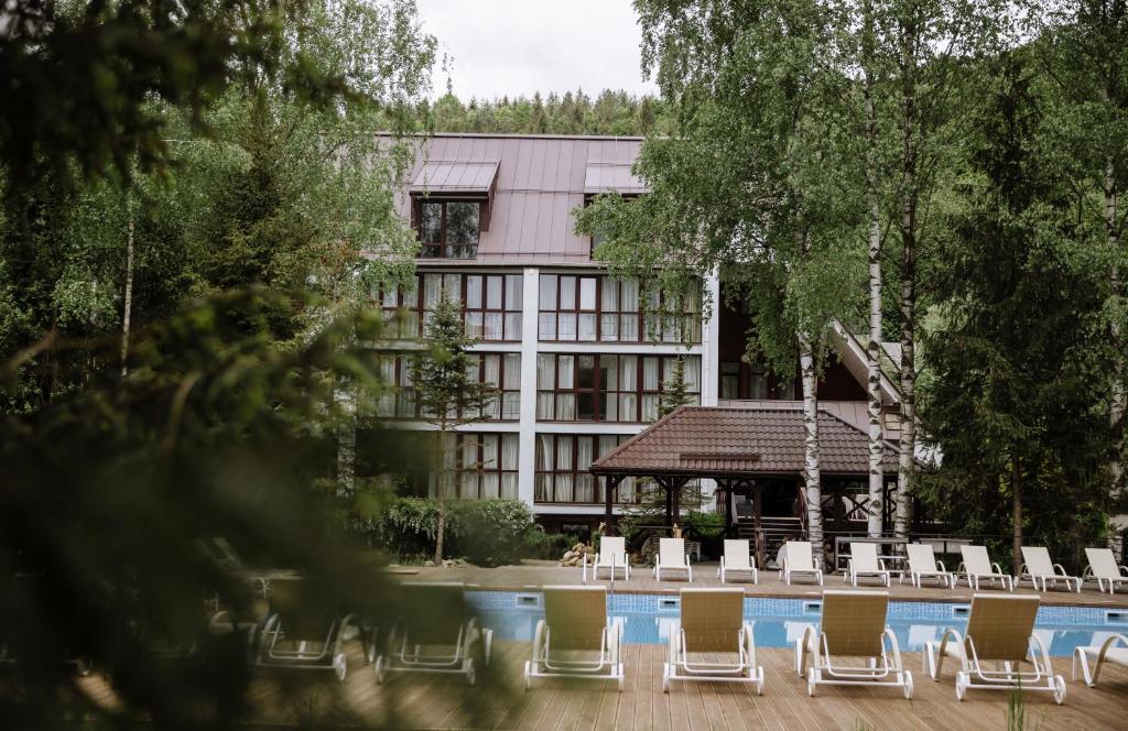 un groupe de chaises assises devant un bâtiment dans l'établissement Yaremche Club Hotel, à Yaremtche