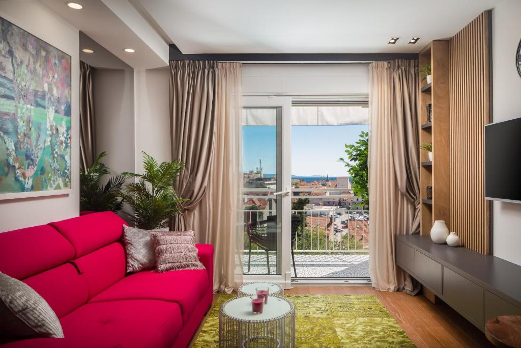 a living room with a red couch and a large window at V Luxury Apartment in Split