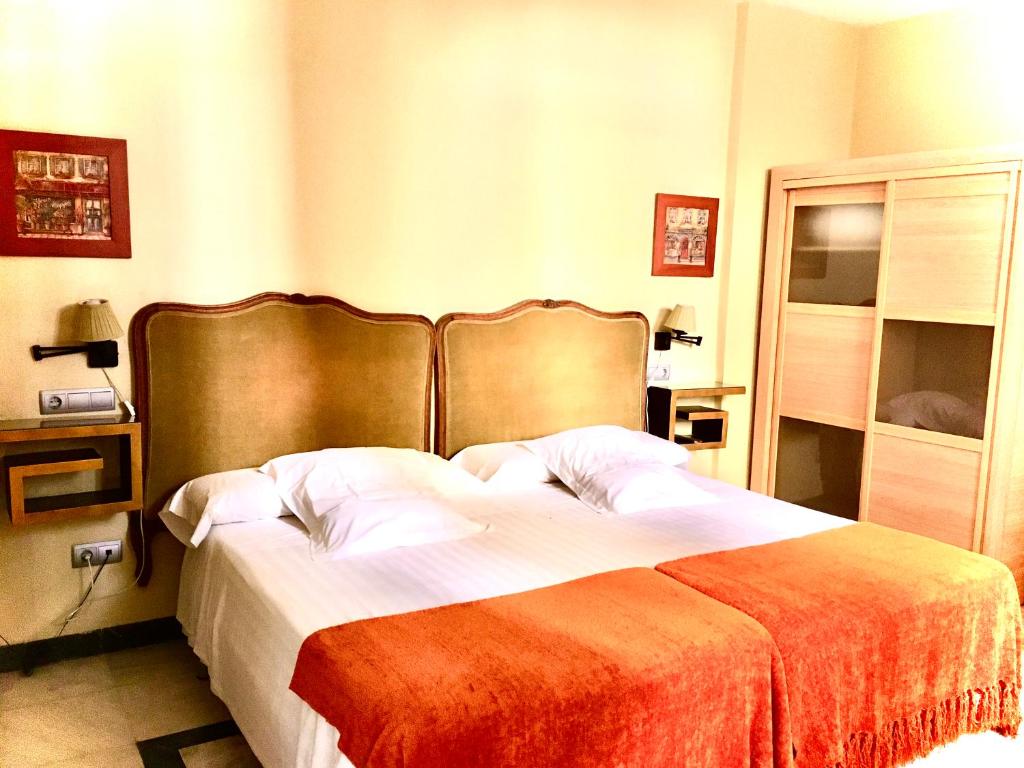 A bed or beds in a room at Hotel Conde de Cárdenas