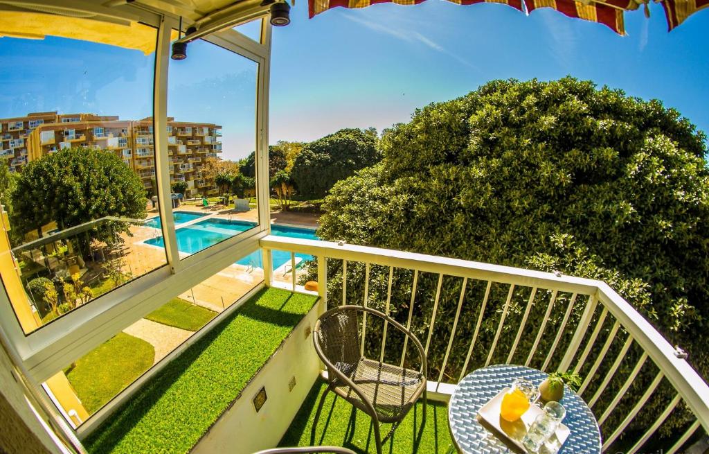 un balcon avec une table et des chaises et une piscine dans l'établissement IRIS Nº 131 Benalmadena, à Benalmádena