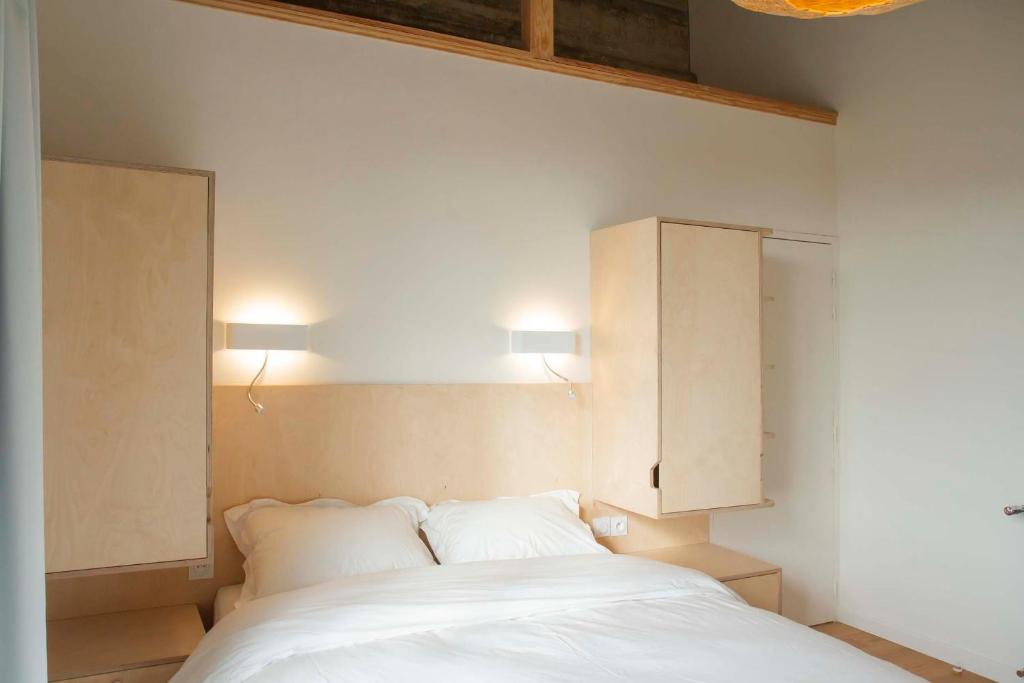 - une chambre avec un lit blanc et 2 oreillers dans l'établissement Une chambre à l'Economat, à Bordeaux