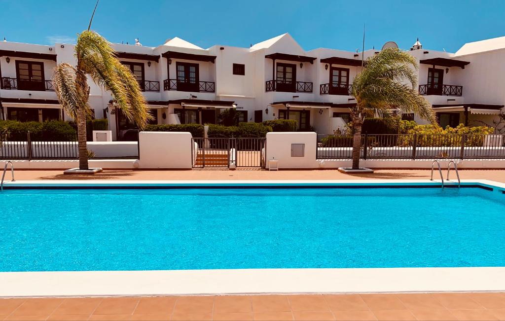a blue swimming pool in front of a building at Lovely Casa Felicidad, swimming pool, Wifi x private garden in Playa Blanca