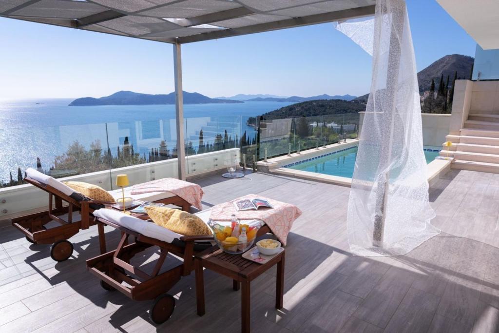 uma varanda de uma casa com vista para o oceano em Luxury Villa Malena with private heated pool and amazing sea view in Dubrovnik - Orasac em Zaton